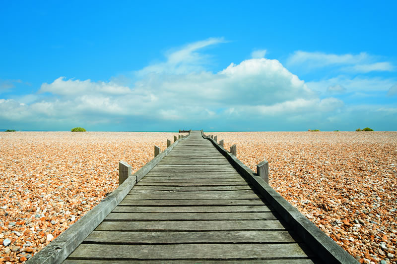 wooden path on beach pebbles