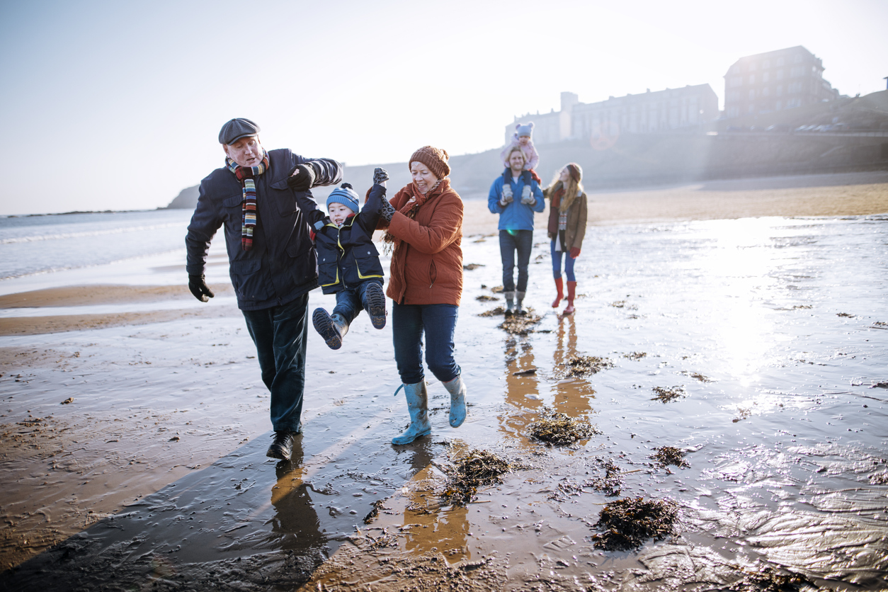 Multi- Generation Family Walking Along the Beach