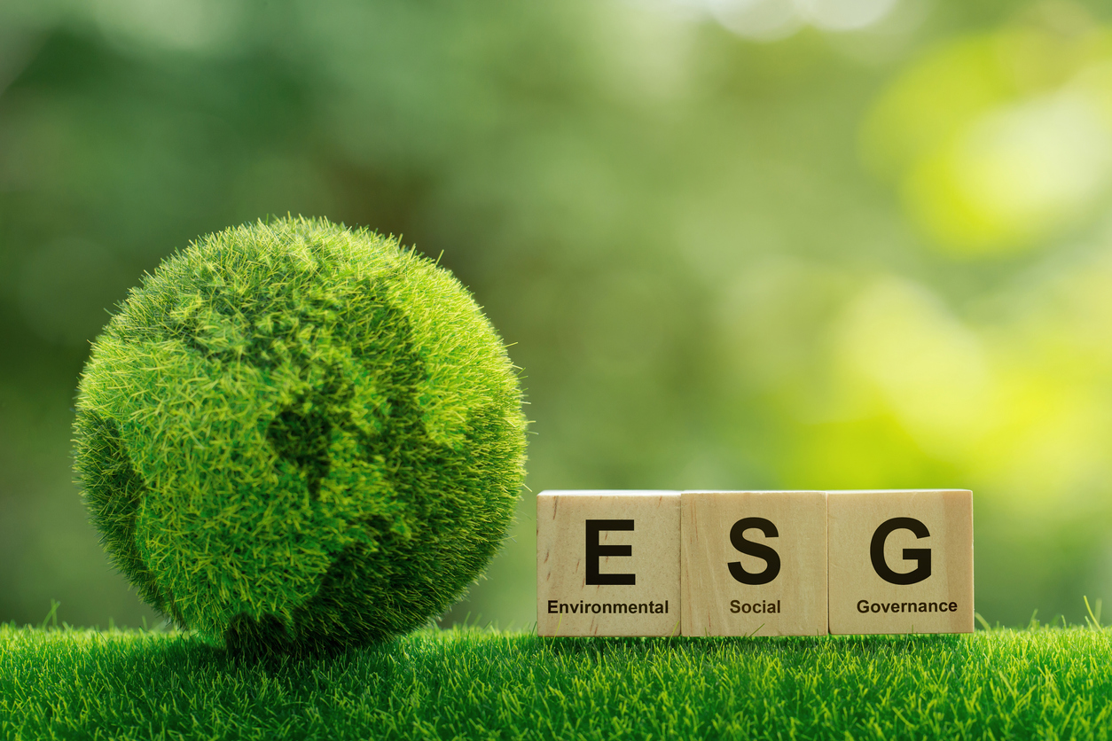 Graphic of a green globe alongside wooden blocks spelling out ESG