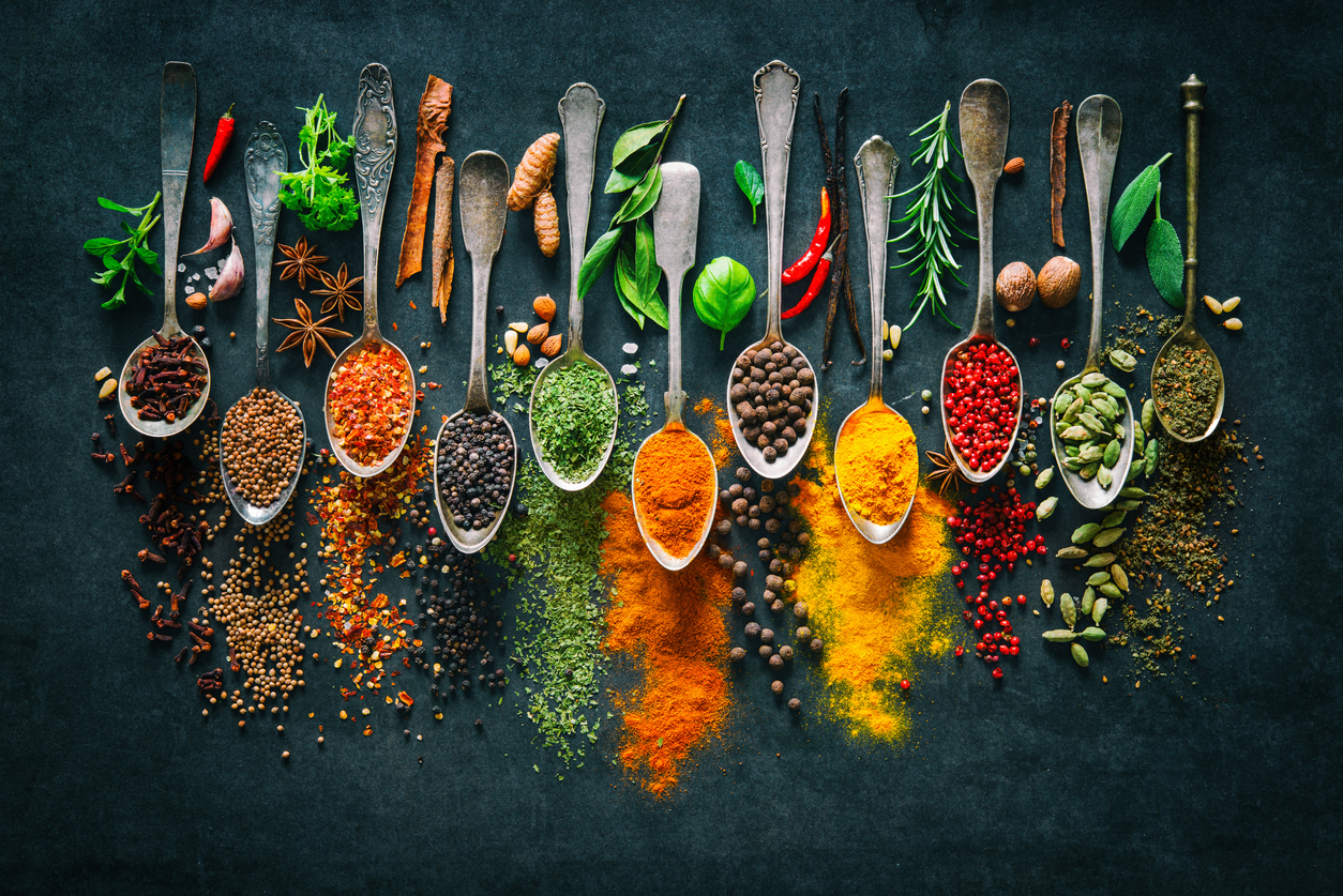 Different colourful spices in an array of spoons