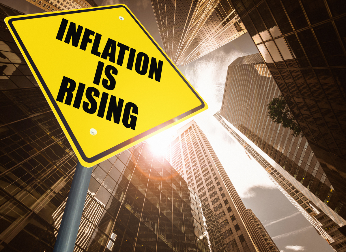 inflation is rising sign post looking up at skyscrapers -