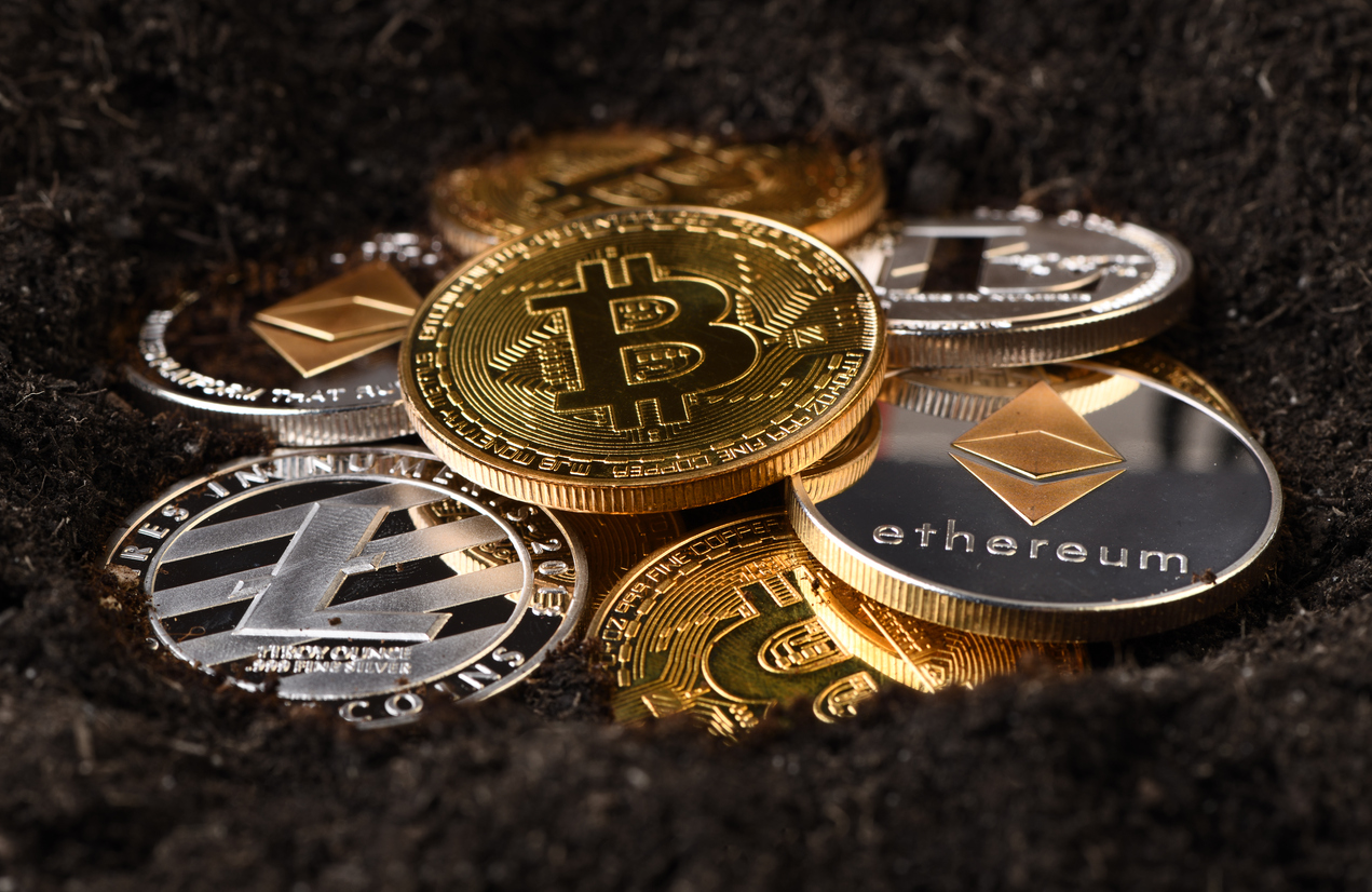 Cryptocurrency coins in soil symbolising cryptocurrency mining - Cryptocurrencies risks
