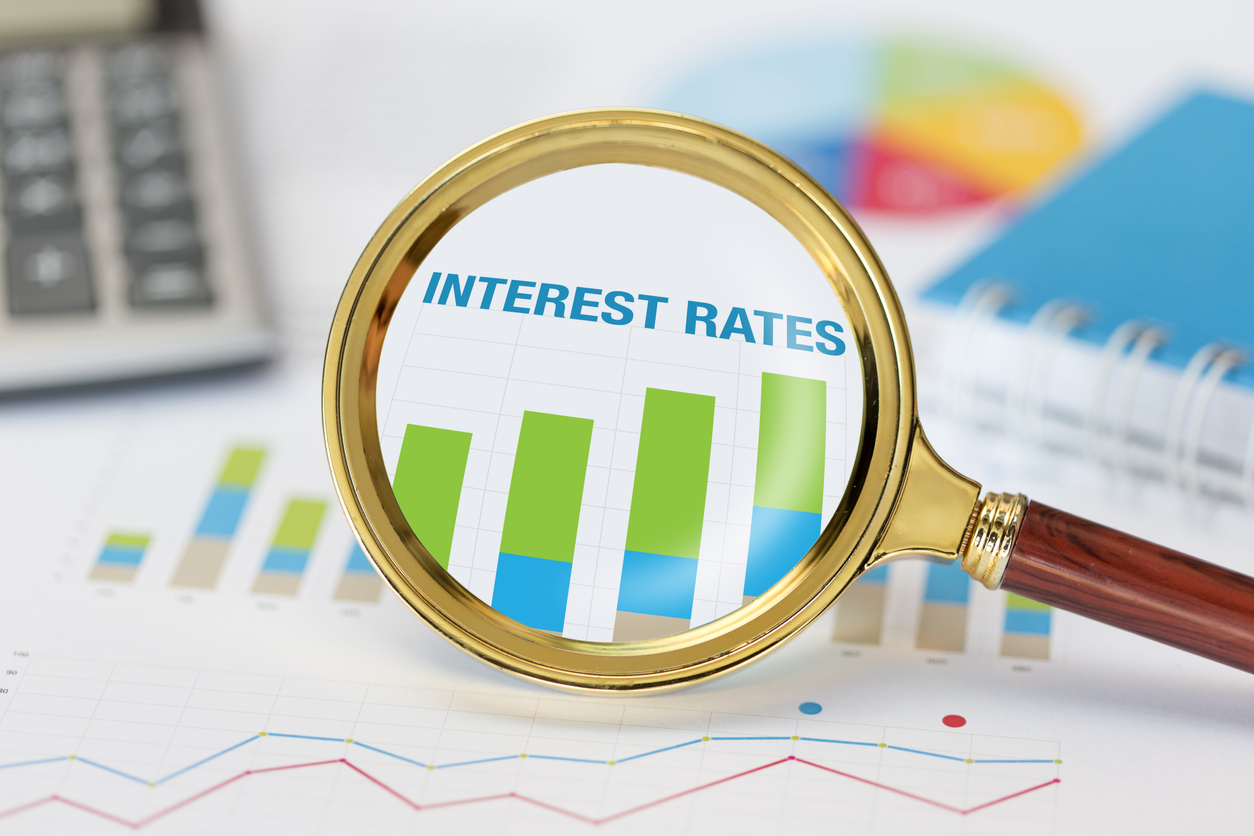 Magnifying glass over document reading 'interest rates' - Why have interest rates increased