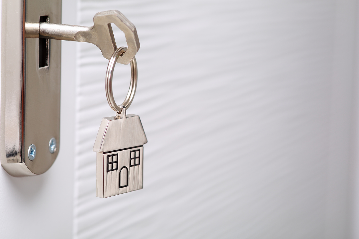 Key in lock with a keyring shaped like a house - Tax loophole closing on second homes