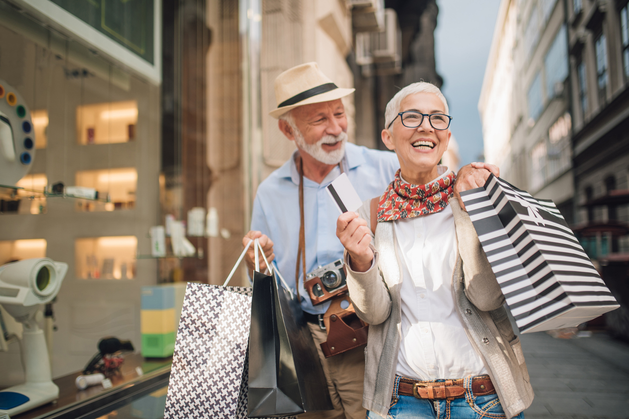 Mature couple with shopping bags spending their retirement savings