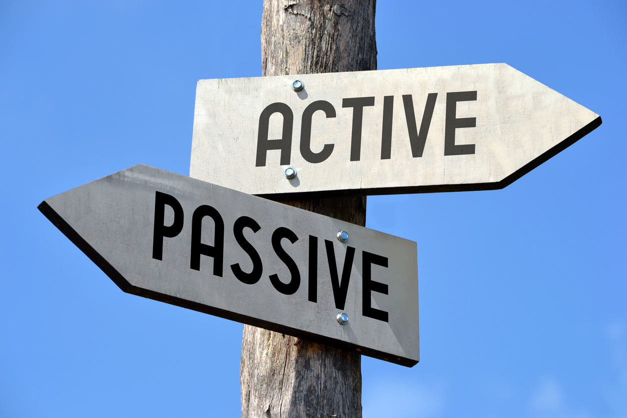 Wooden signpost with two arrows, one reading Active one reading Passive - Do Active Managers add value