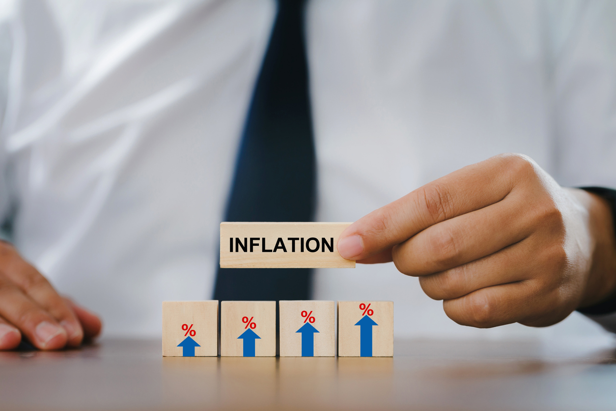 Businessman Hand holding a wooden block with the word inflation - September Consumer Prices Index
