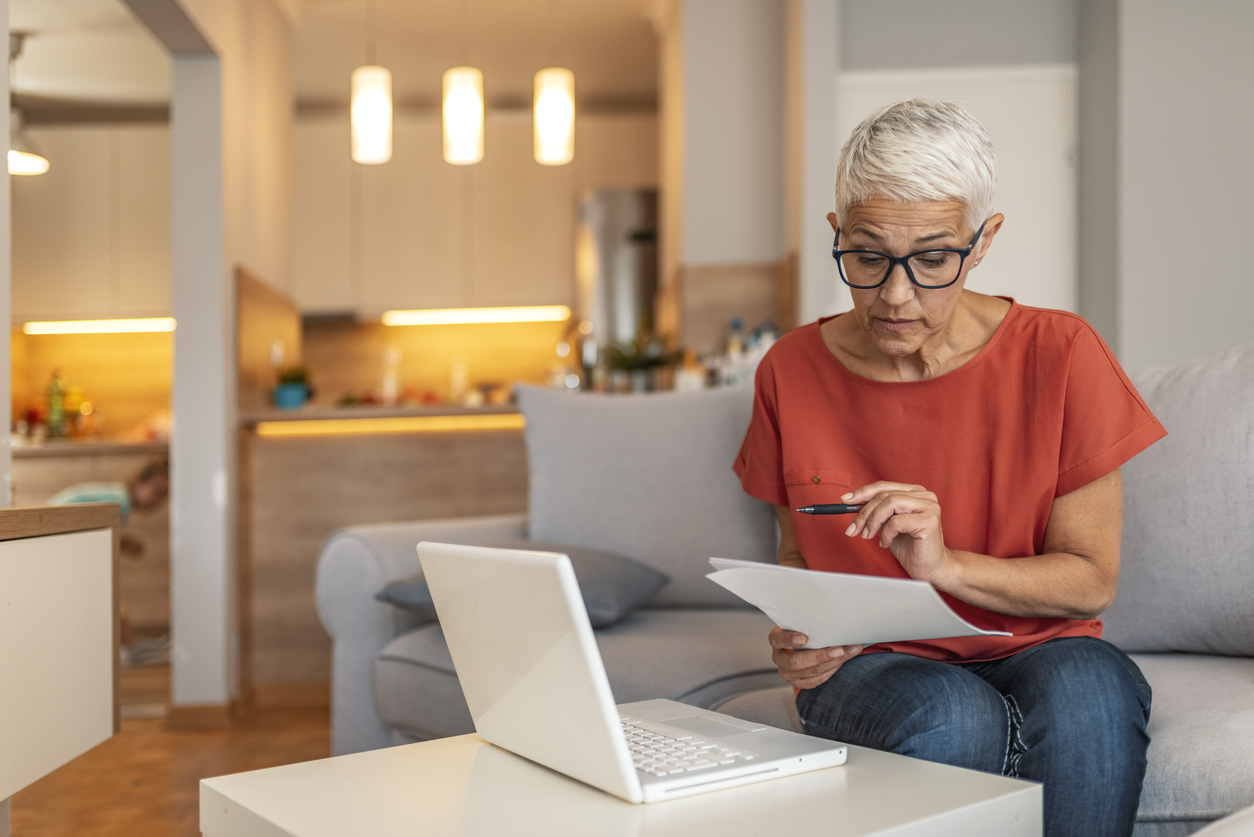 Mature woman reviewing pension options on a laptop at home