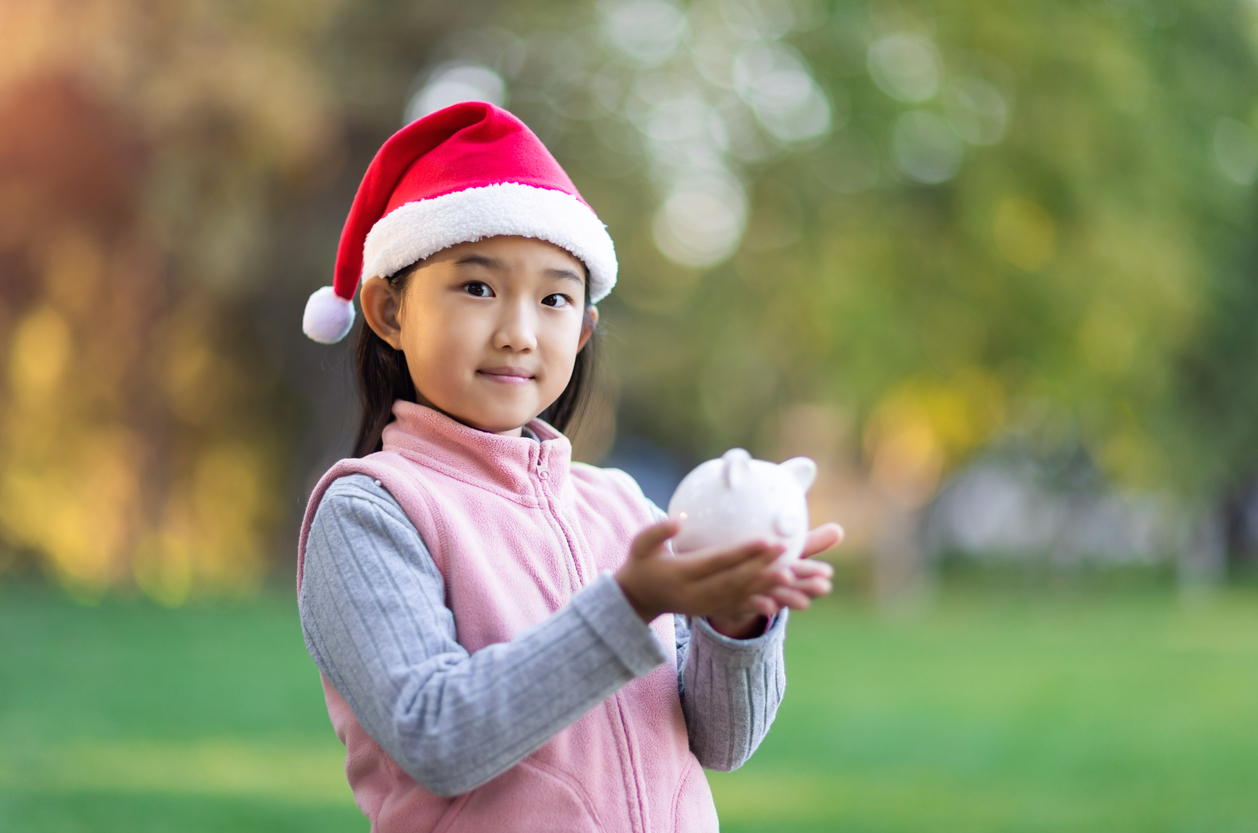 Christmas Girl Holding Piggy Bank - Looking for alternative Christmas presents?
