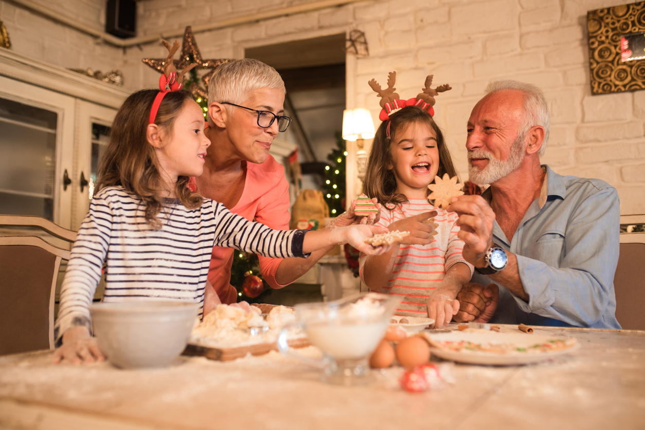 Grandparents making festive cookies with grandchildren - A helping hand for grandchildren