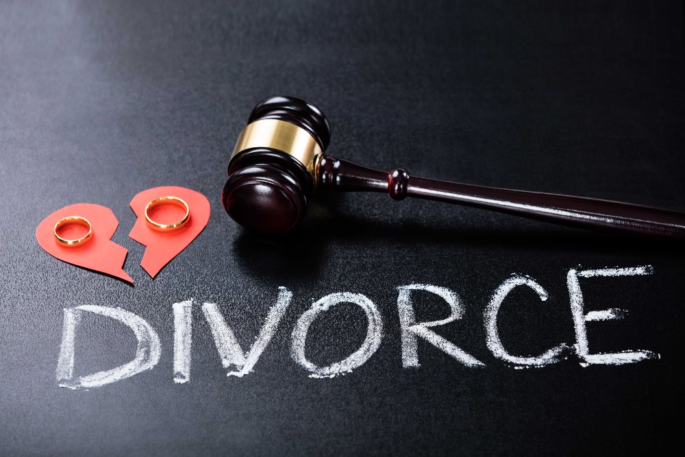 How financial planning can help in divorce - broken heart with rings next to a gavel on a blackboard with writing 'divorce'