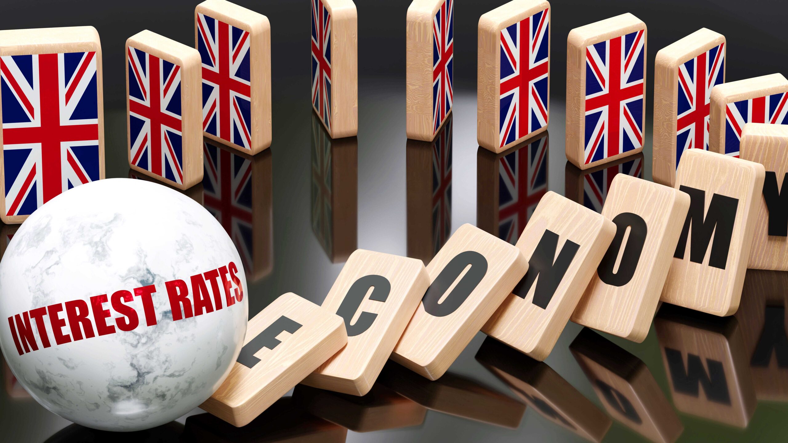Graphic showing dominoes with Union Jack on them standing up, and dominoes spelling out the word 'economy' falling down, alongside a spherical object with 'interest rates' printed on the side - representing interest rates negatively affecting the UK economy