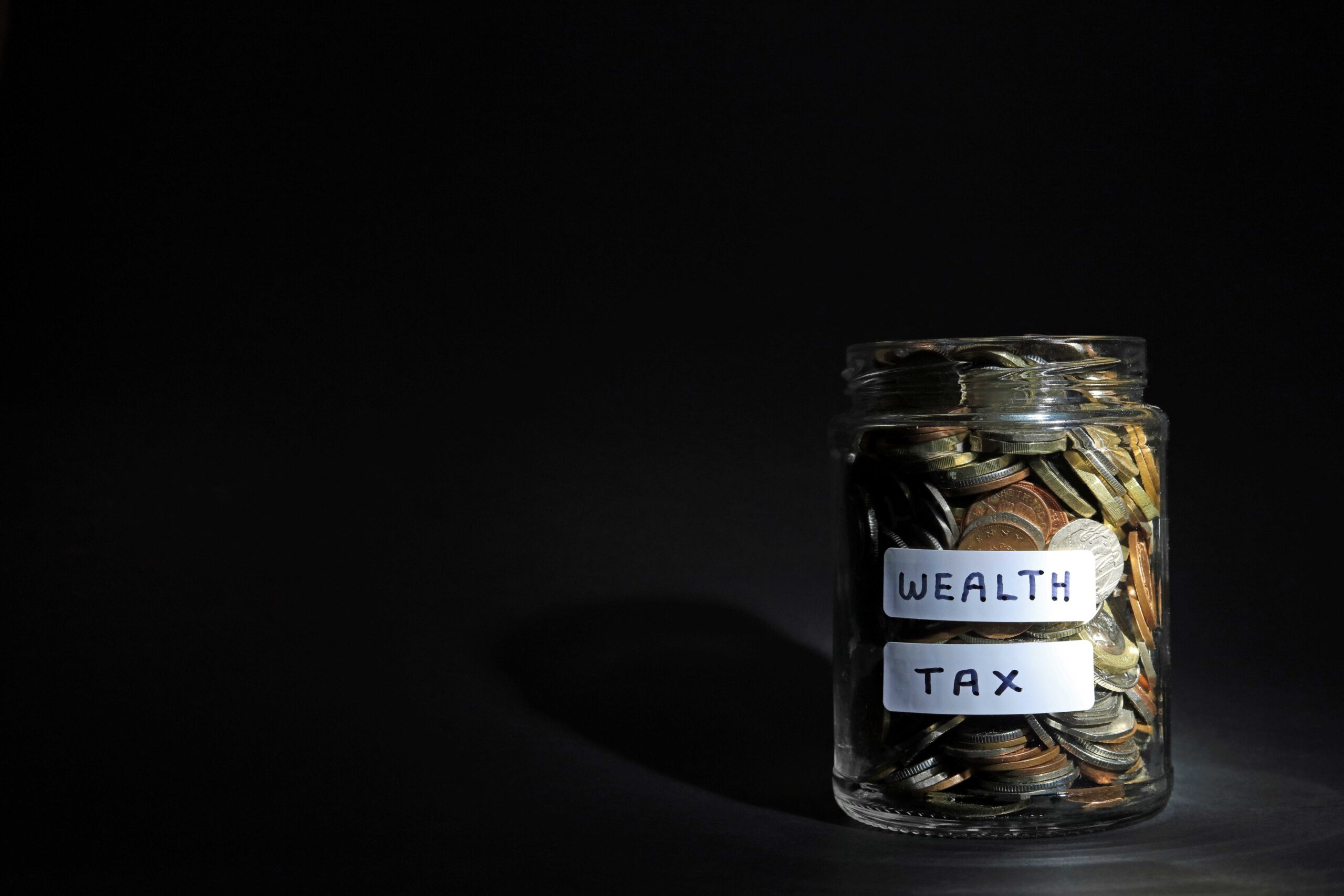 Graphic of a jar containing coins labelled with 'Wealth Tax'