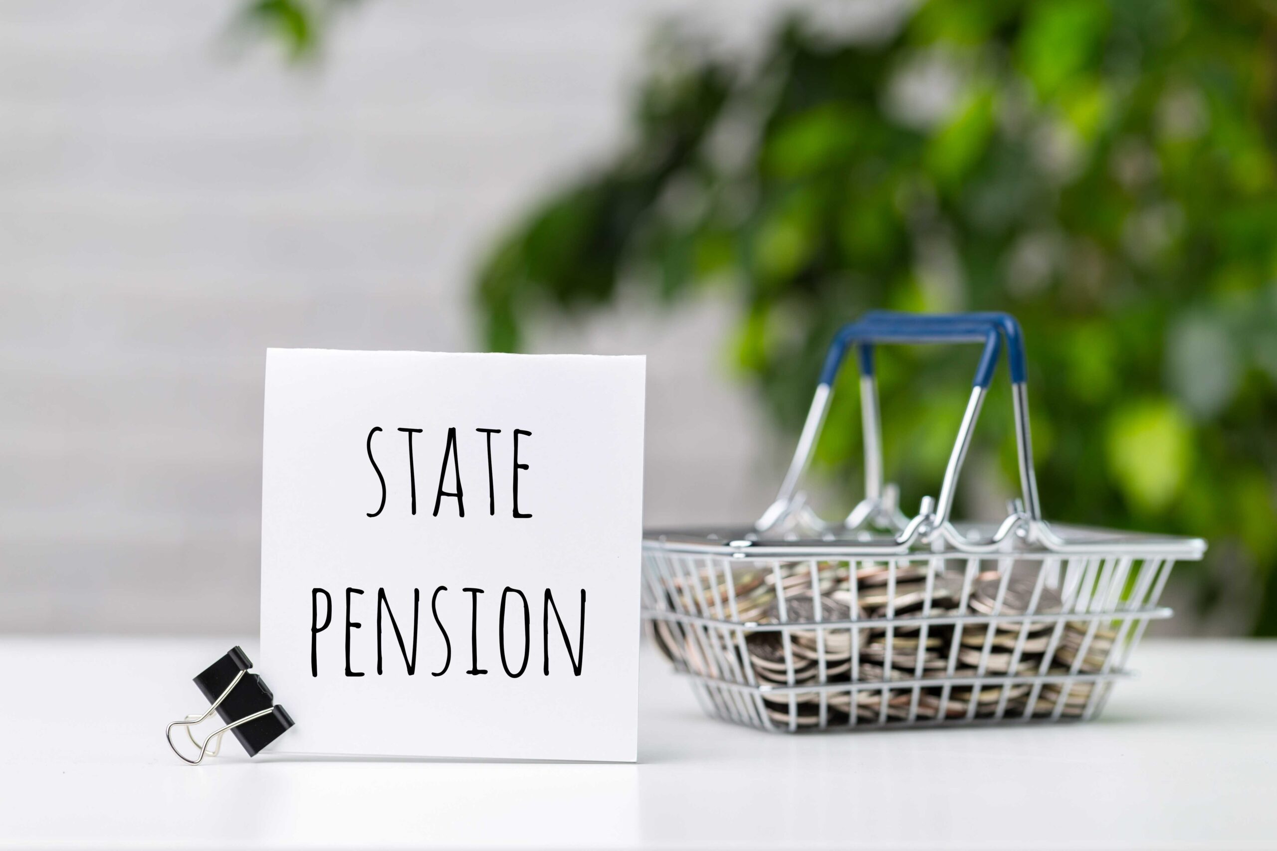 Graphic of a sign reading 'State Pension' with a basket full of coins alongside it.